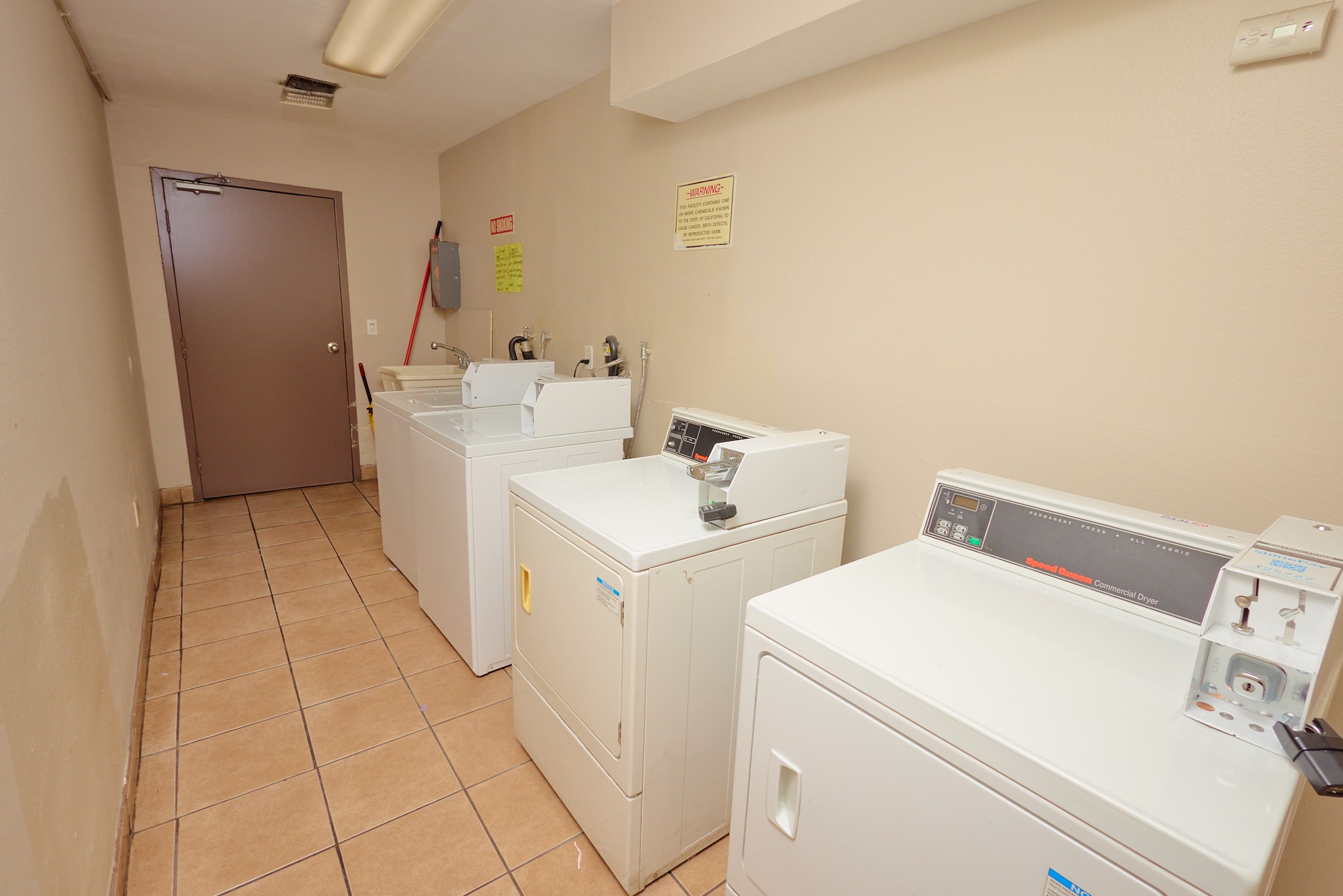 A clean, empty room with a washing machine and dryer.